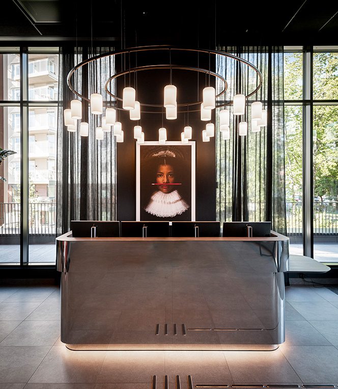 Stilig resepsjonsområde med stort skrivebord, plassert på Radisson RED i Oslo Økern.